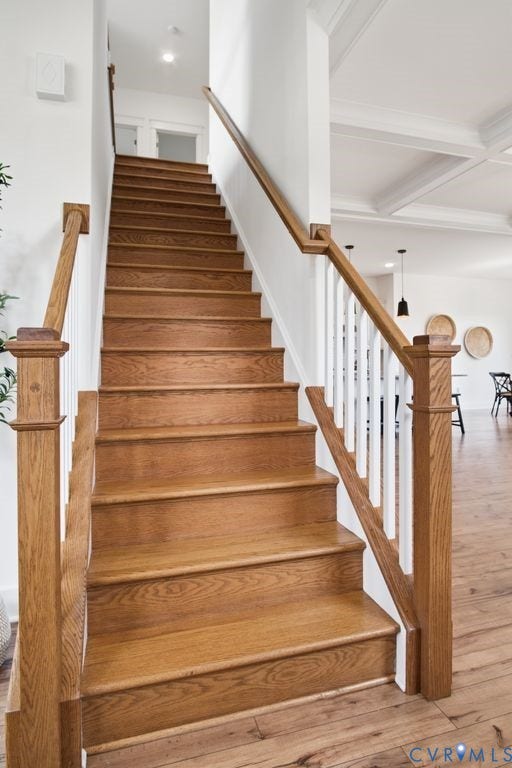 6991 Carden Park Drive, Carden Park, Moseley, VA 23120 Hardwood staircase featuring solid wood newel posts and handrails, white balusters, and wood-finish flooring extending into the adjacent space