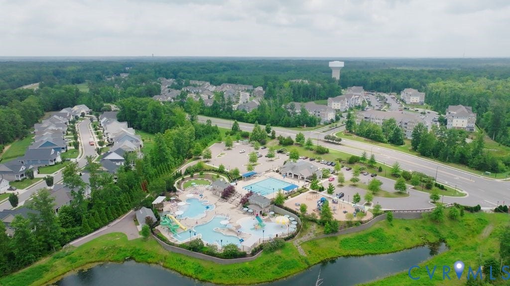 6991 Carden Park Drive, Carden Park, Moseley, VA 23120 Expansive community amenity center featuring multiple pools, water slides, a playground, and a clubhouse building
