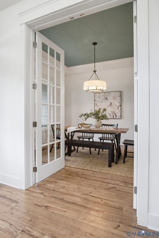 6991 Carden Park Drive, Carden Park, Moseley, VA 23120 Entryway with wood-finish flooring opening to a room featuring a rectangular chandelier, a light blue ceiling, and white trim