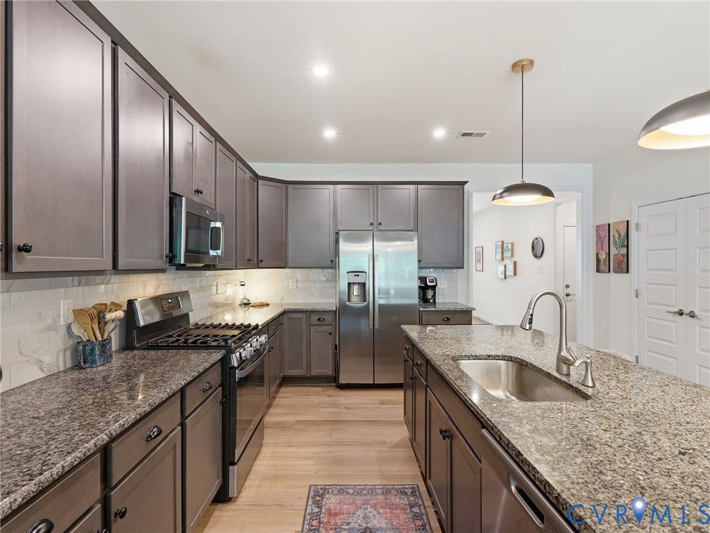 9237 Cerulean Place, Richmond, VA 23238 This well designed kitchen comes complete with a spacious pantry, custom contemporary wood cabinetry, and a luxurious island with built-in sink.