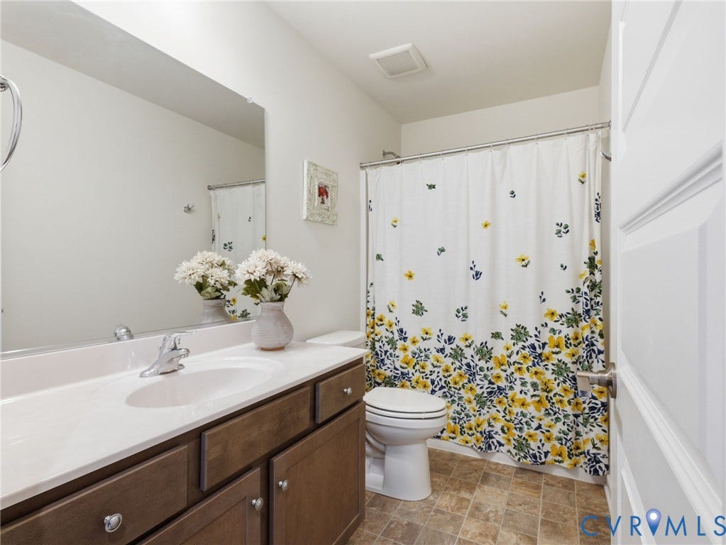 9237 Cerulean Place, Richmond, VA 23238 A stylish and practical upstairs hall bath boasting a generous vanity, statement mirror, and full tub/shower combination for ultimate flexibility... perfect for both guests and everyday living.