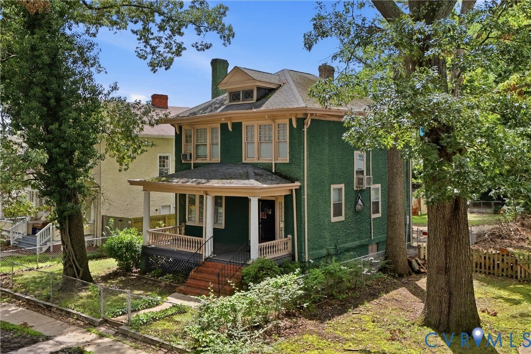3110 North Avenue, Brookland Park, Richmond, VA 23222 Two-story stucco exterior with a covered porch, white column balusters, and a shingled roof