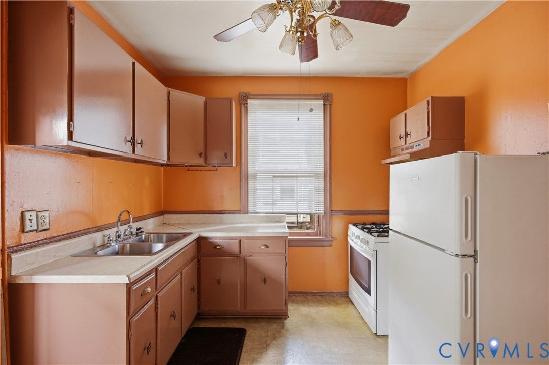 3110 North Avenue, Brookland Park, Richmond, VA 23222 Galley-style kitchen featuring warm orange walls, wood-finish cabinetry, laminate countertops, a white refrigerator, electric range, undermount sink, ceiling fan with light fixture, and a window with blinds providing natural light