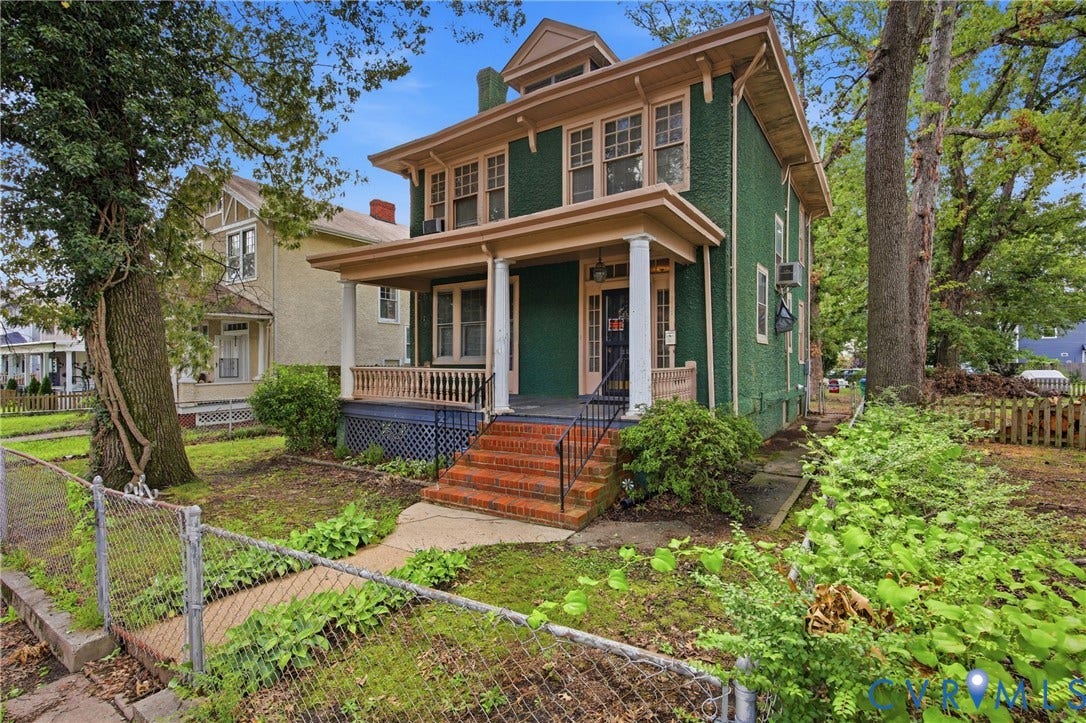 3110 North Avenue, Brookland Park, Richmond, VA 23222 Classic Colonial Revival home featuring a distinctive green exterior with cream trim, brick foundation, and a welcoming front porch with decorative railings