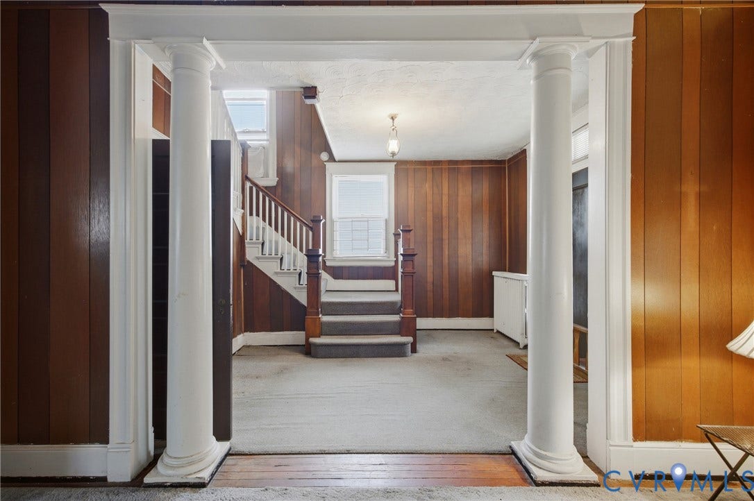 3110 North Avenue, Brookland Park, Richmond, VA 23222 Architectural columns frame an entryway with a wood-paneled wall, a staircase with wood banisters, and a window with white trim