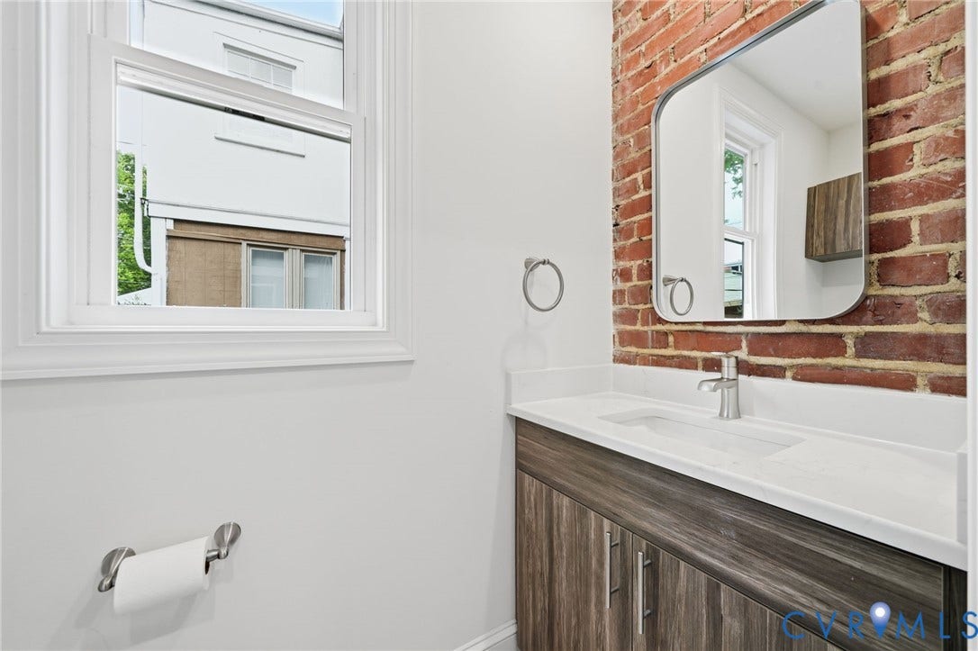 2919 Grayland Avenue, Byrd Park/ Carytown, Richmond, VA 23221 Bathroom vanity featuring a light countertop, integrated sink, and wood-finish cabinetry