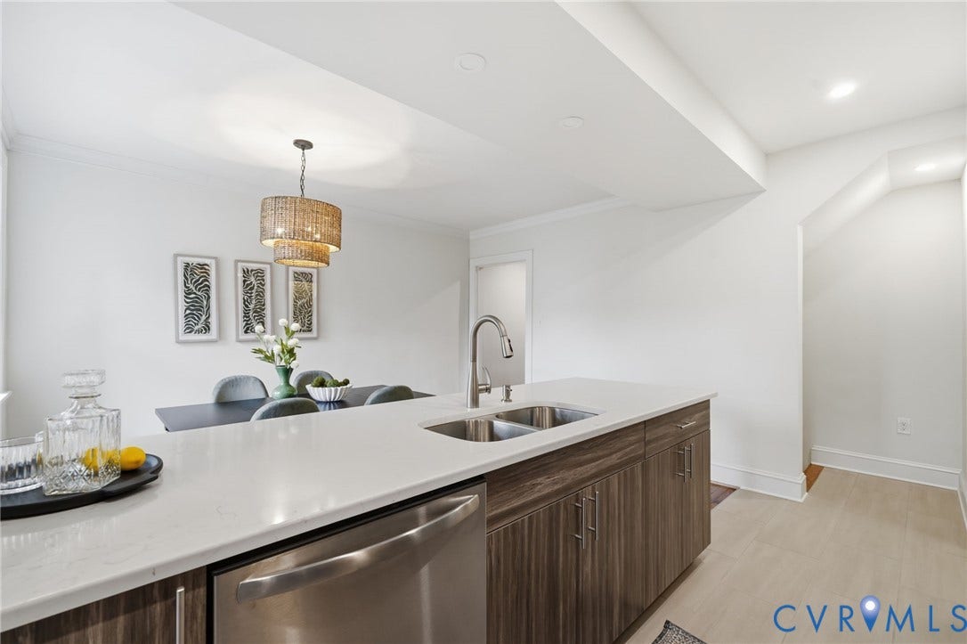 2919 Grayland Avenue, Byrd Park/ Carytown, Richmond, VA 23221 Kitchen island featuring a double-basin stainless steel sink, pull-down faucet, integrated stainless steel dishwasher, and a light-toned countertop