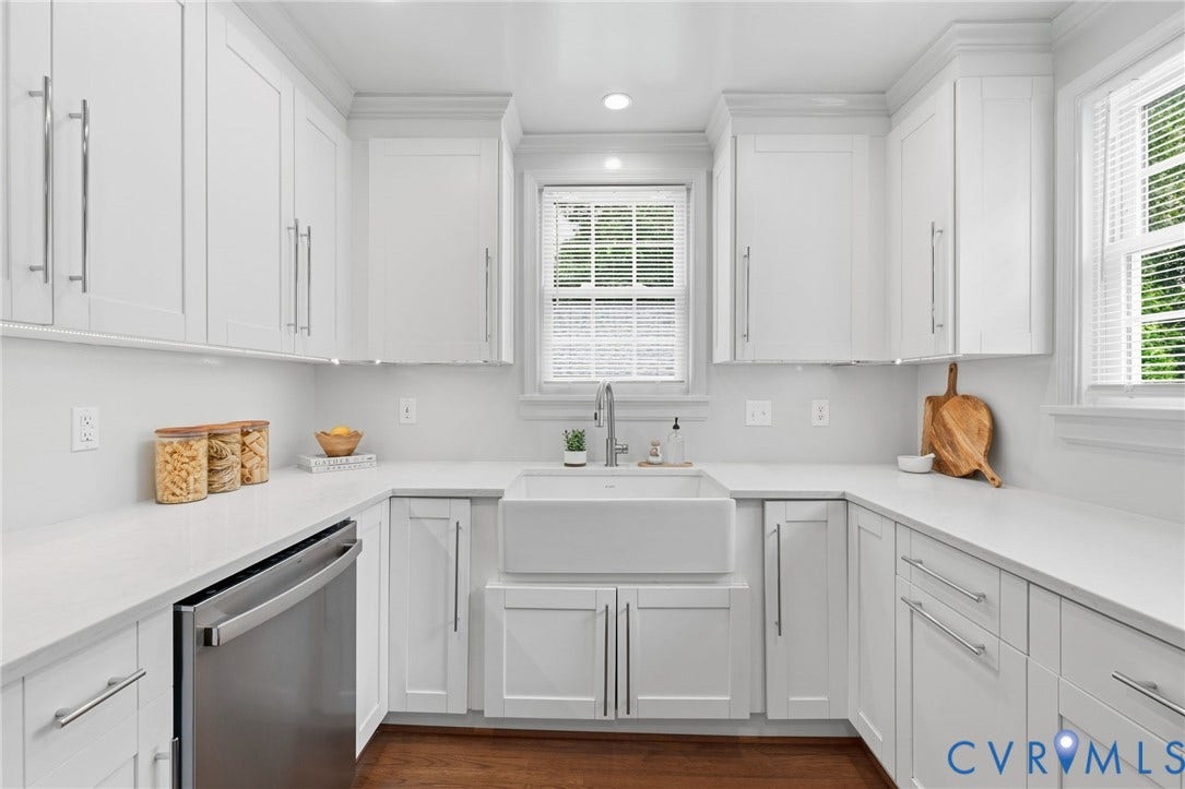 1002 Normandy Drive, Henrico, VA 23229 White shaker-style cabinetry with chrome hardware, farm sink, stainless steel dishwasher, and light-toned countertops