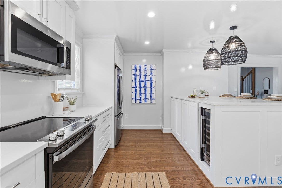 1002 Normandy Drive, Henrico, VA 23229 White cabinetry with modern hardware, stainless steel appliances, wood-finish flooring, recessed lighting, and a built-in beverage cooler