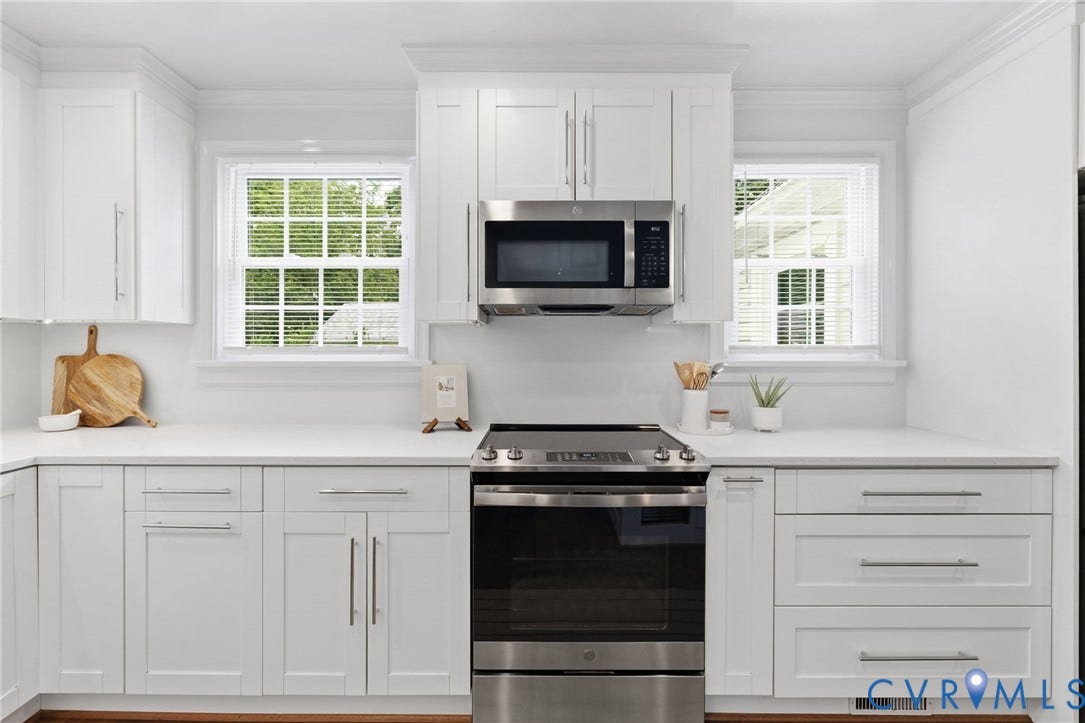 1002 Normandy Drive, Henrico, VA 23229 White shaker-style cabinetry with chrome hardware, white solid surface countertops, and stainless steel appliances