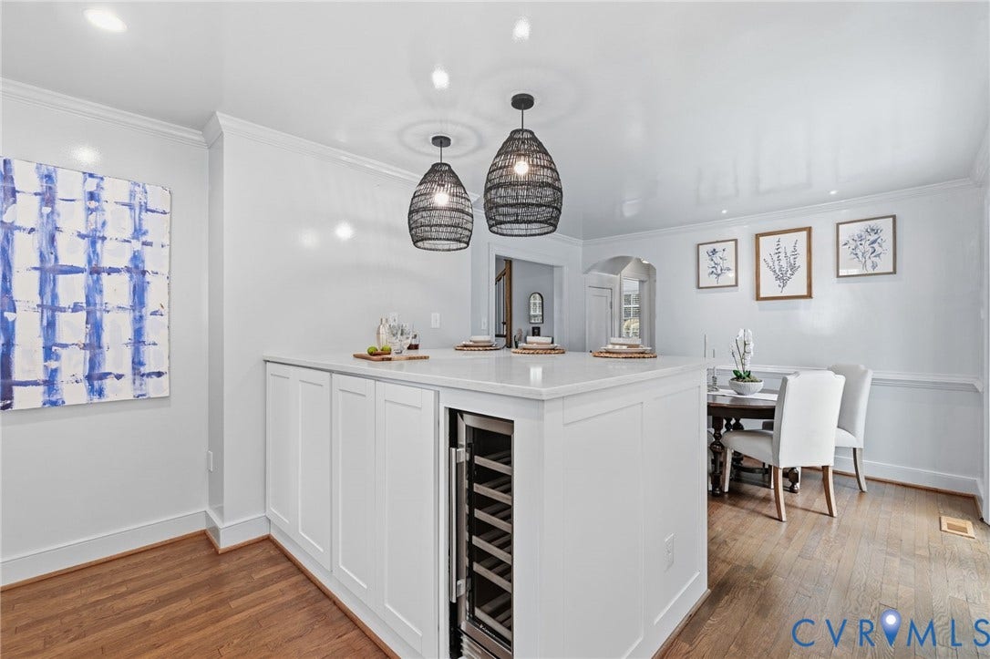 1002 Normandy Drive, Henrico, VA 23229 White cabinetry with integrated beverage refrigerator, light-toned countertop, and two pendant light fixtures