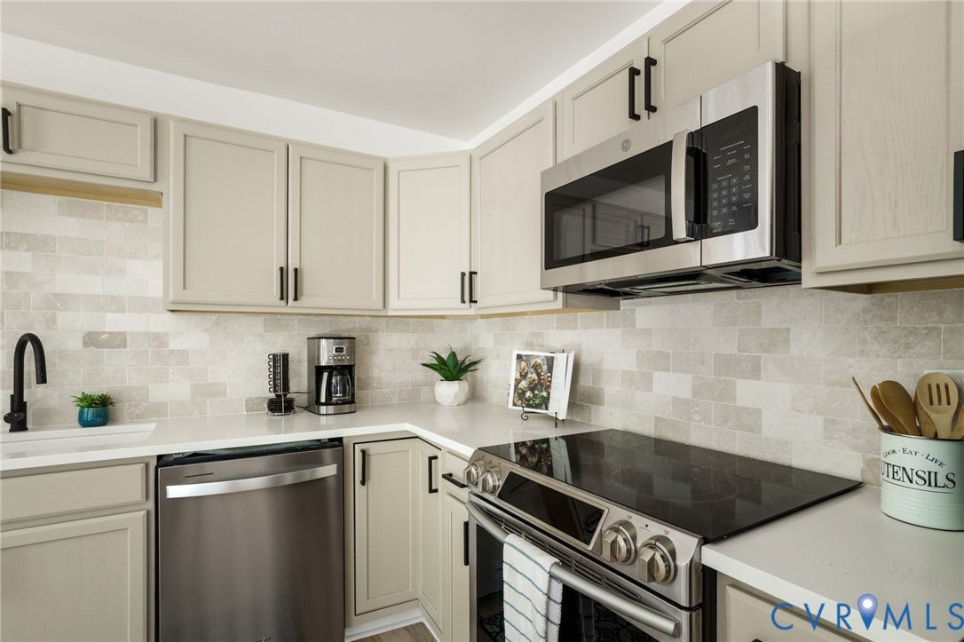 3056 Davis Mill Road, Goochland, VA 23063 Modern kitchen featuring light-toned cabinetry, stainless steel appliances, a tile backsplash, light countertops, and a black gooseneck faucet