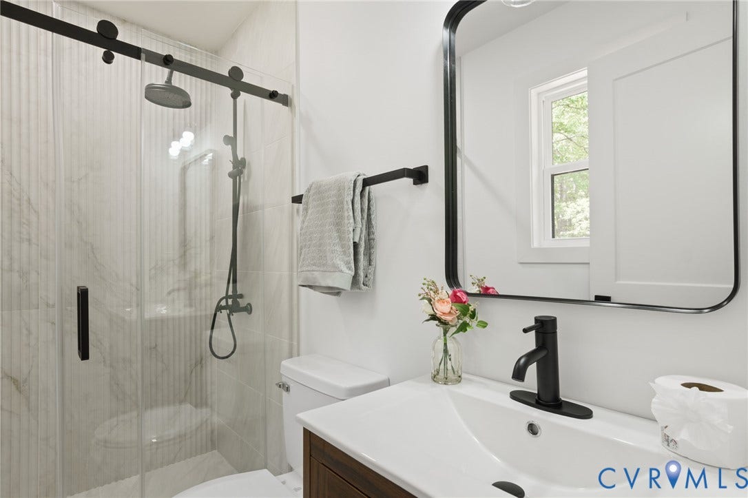 3056 Davis Mill Road, Goochland, VA 23063 Contemporary bathroom featuring a glass-enclosed shower with matte black fixtures, a rain shower head, and vertical-ribbed tile surround
