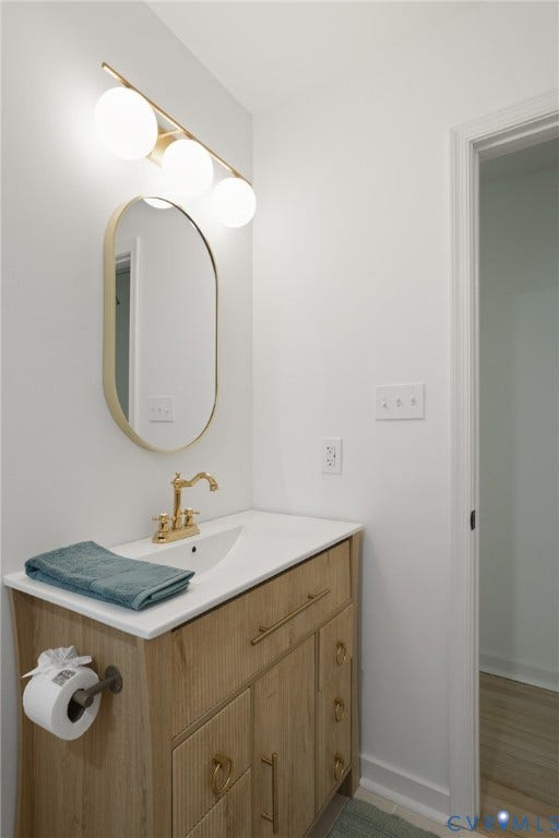 3056 Davis Mill Road, Goochland, VA 23063 Bathroom vanity featuring a light wood-finish cabinet with gold hardware, a white countertop with an integrated sink, and a gold-tone faucet