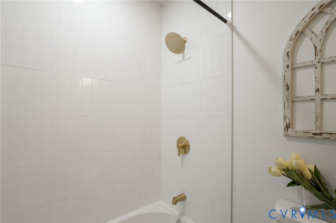 3056 Davis Mill Road, Goochland, VA 23063 Bathtub/shower combination featuring white subway tile surround, gold-finish rain shower head, gold-finish shower controls, and gold-finish tub spout