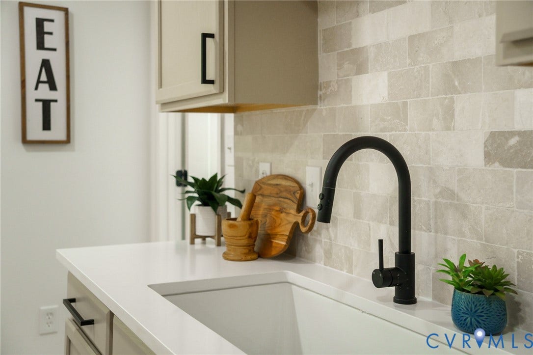 3056 Davis Mill Road, Goochland, VA 23063 Kitchen sink area featuring a matte black gooseneck faucet, light-toned subway tile backsplash, white countertop, and light cabinetry with dark hardware
