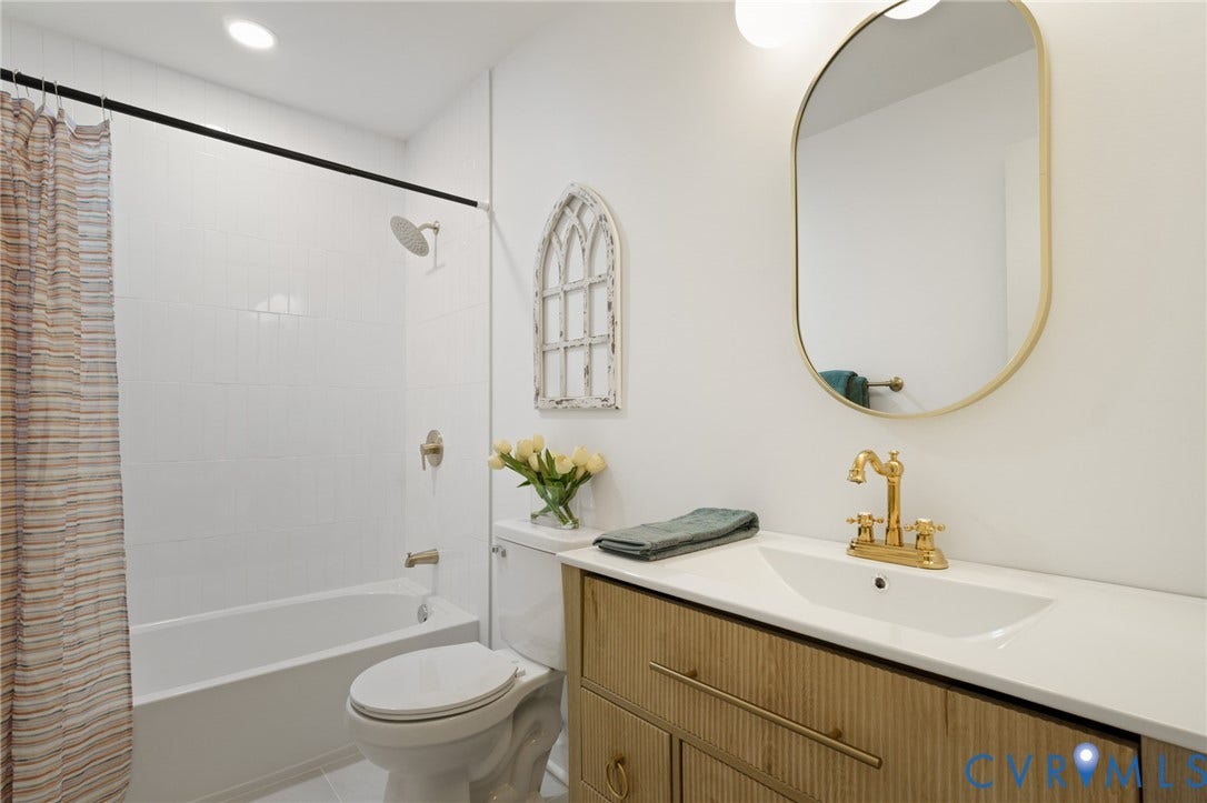 3056 Davis Mill Road, Goochland, VA 23063 Bathroom featuring a wood-finish vanity with a white countertop and integrated sink, gold-tone faucet, and an oval mirror with a gold-tone frame
