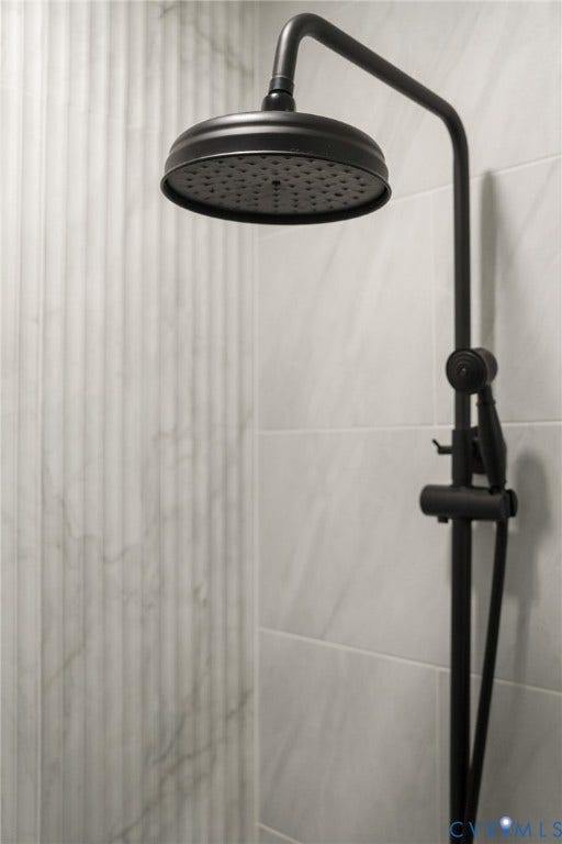 3056 Davis Mill Road, Goochland, VA 23063 Matte black rain shower head with coordinating handheld shower, set against large format light-toned tile and fluted accent tile