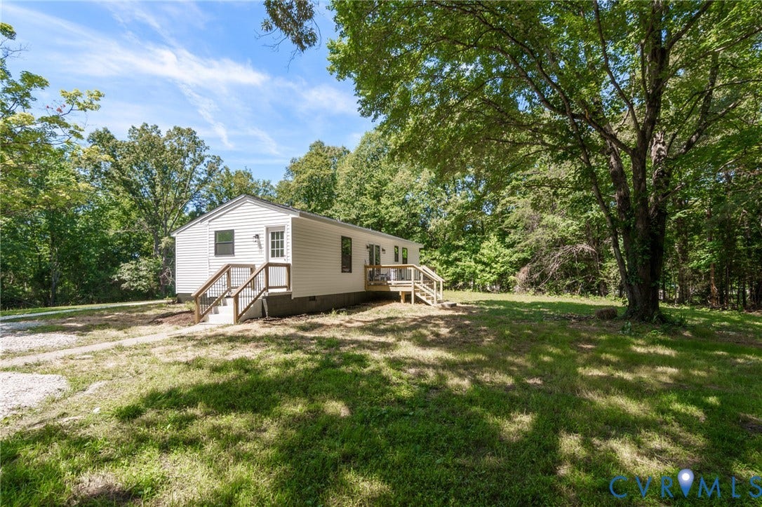 3056 Davis Mill Road, Goochland, VA 23063 White siding exterior featuring black-framed windows and two wooden deck entrances