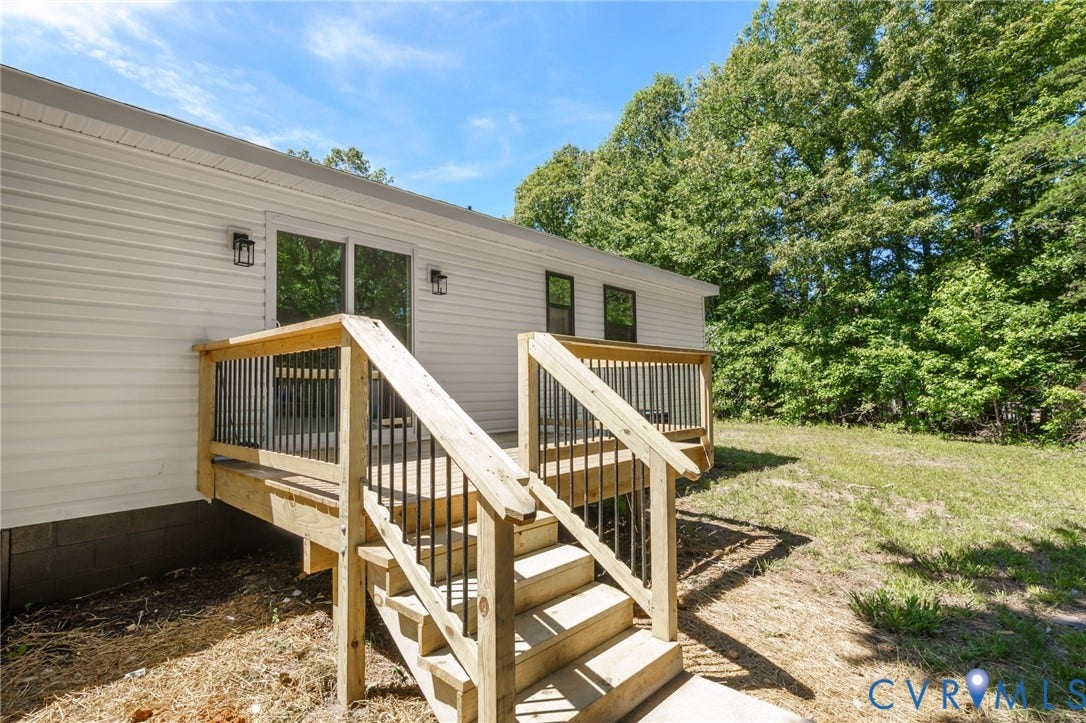 3056 Davis Mill Road, Goochland, VA 23063 Rear exterior featuring white horizontal siding and a wood deck with black metal balusters