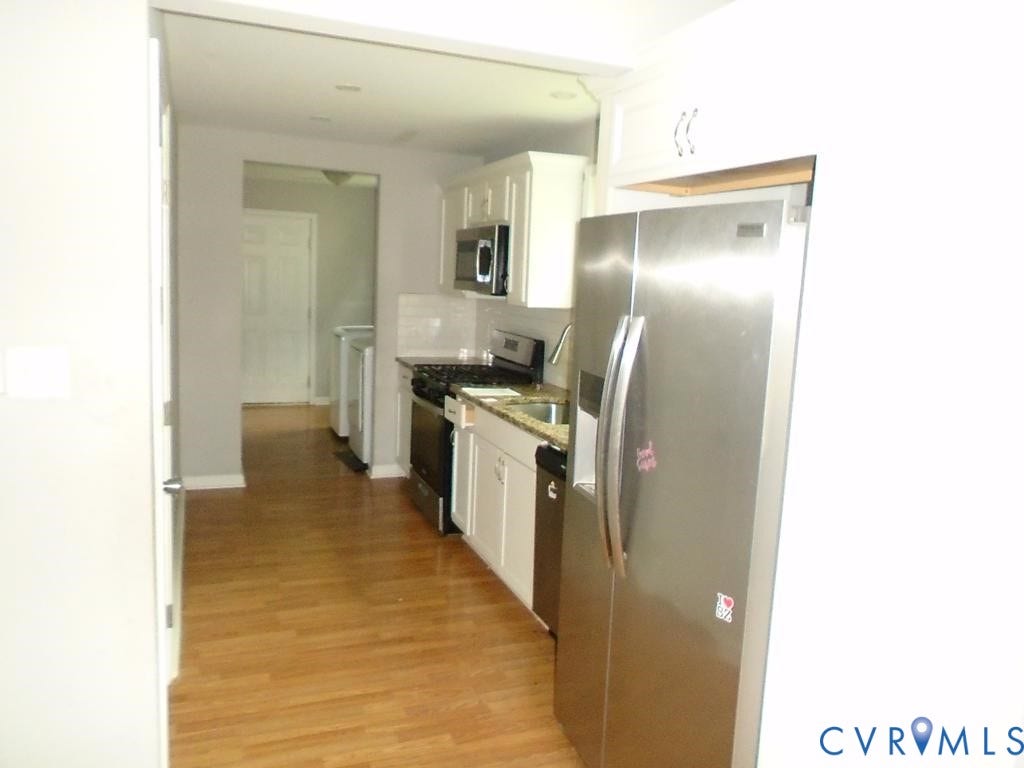3406 Mike Road, Richmond, VA 23234 Kitchen featuring wood-finish flooring, white cabinetry, stainless steel appliances, and light-toned countertops