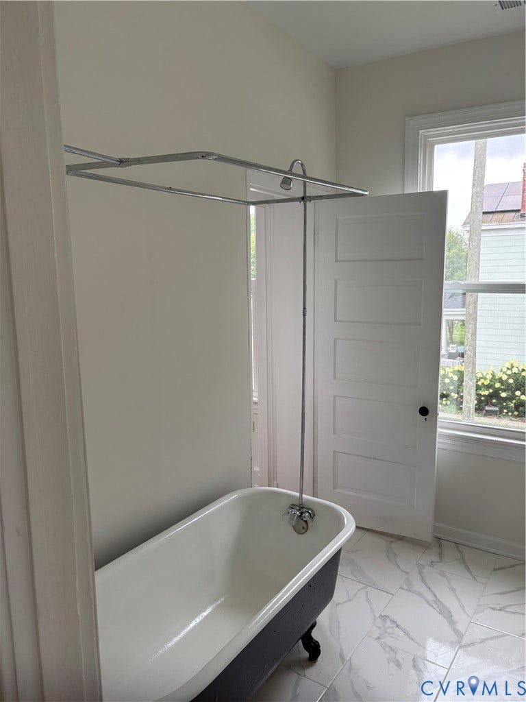 3300 Carolina Avenue, Richmond, VA 23222 Clawfoot tub with an overhead shower fixture, complemented by large format tile flooring
