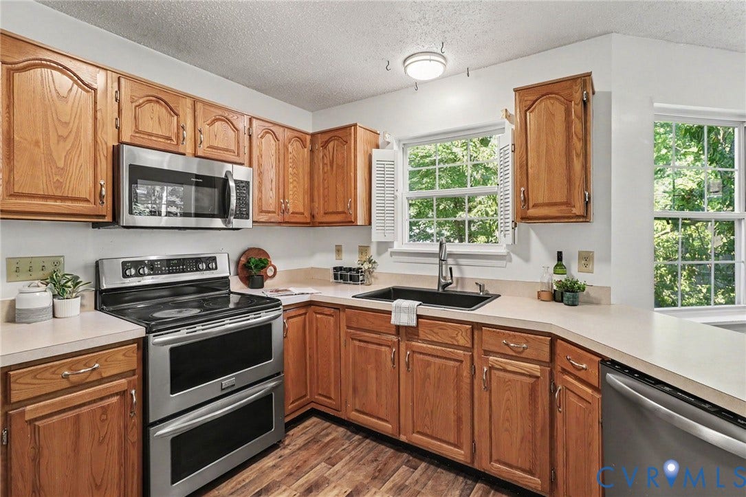 931 Hunters Run Drive, Henrico, VA 23223 Kitchen featuring abundant wood cabinetry, stainless steel appliances, a double oven range, a built-in microwave, and a black composite sink