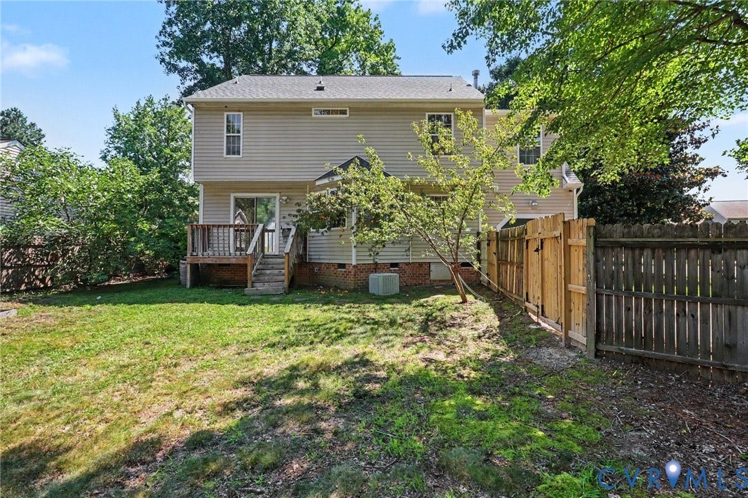931 Hunters Run Drive, Henrico, VA 23223 Expansive rear yard featuring a wooden deck with stairs, a sliding glass door, a wooden privacy fence, and mature perimeter trees