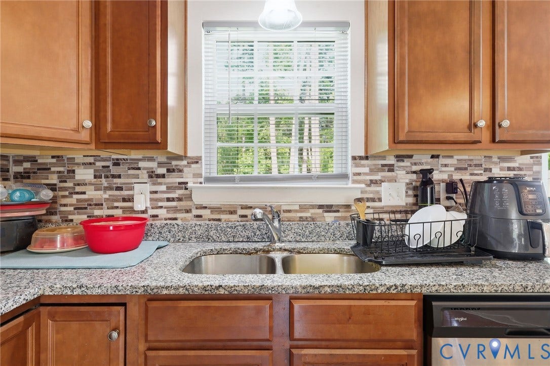 10155 Virginia Road, Glen Allen, VA 23060 Kitchen featuring wood cabinetry, a granite-look countertop, and a mosaic tile backsplash