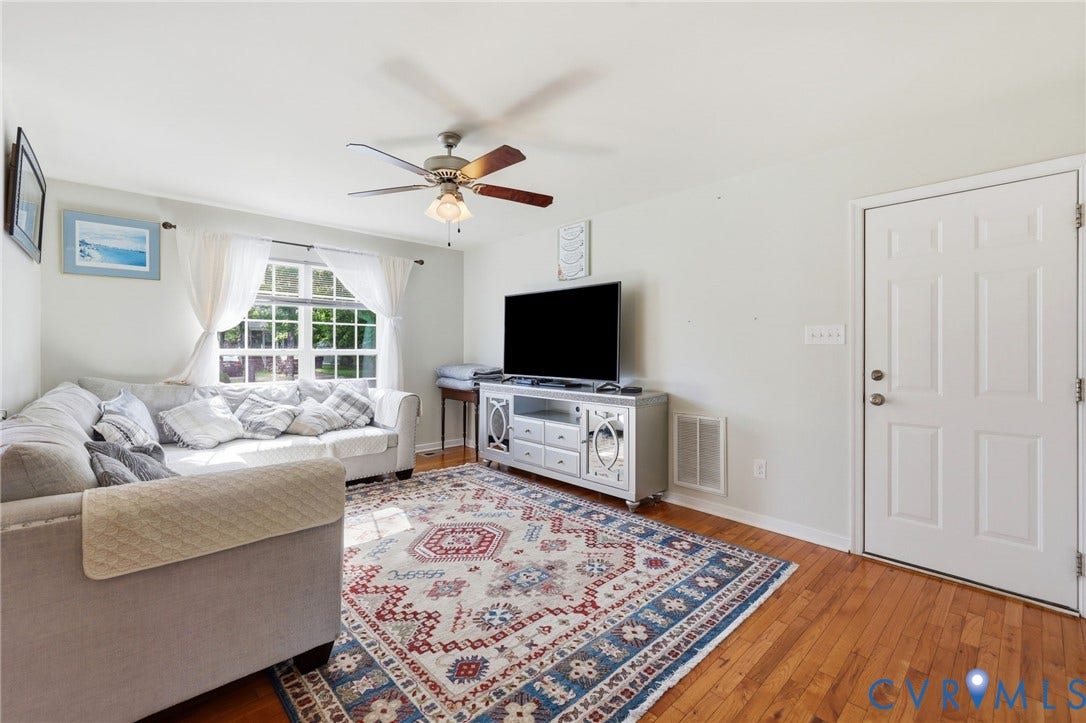 10155 Virginia Road, Glen Allen, VA 23060 Living area featuring wood-finish flooring, a white paneled entry door, and a ceiling fan with integrated lighting