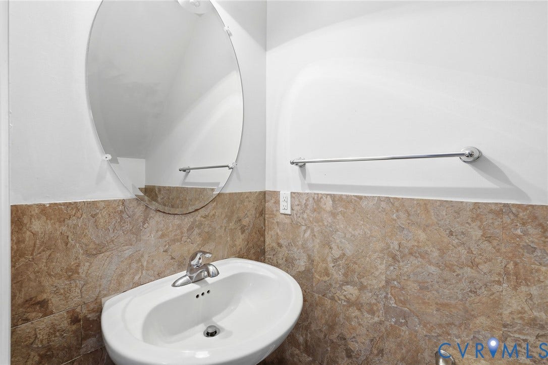 10155 Virginia Road, Glen Allen, VA 23060 Pedestal sink with chrome faucet, complemented by a large oval mirror