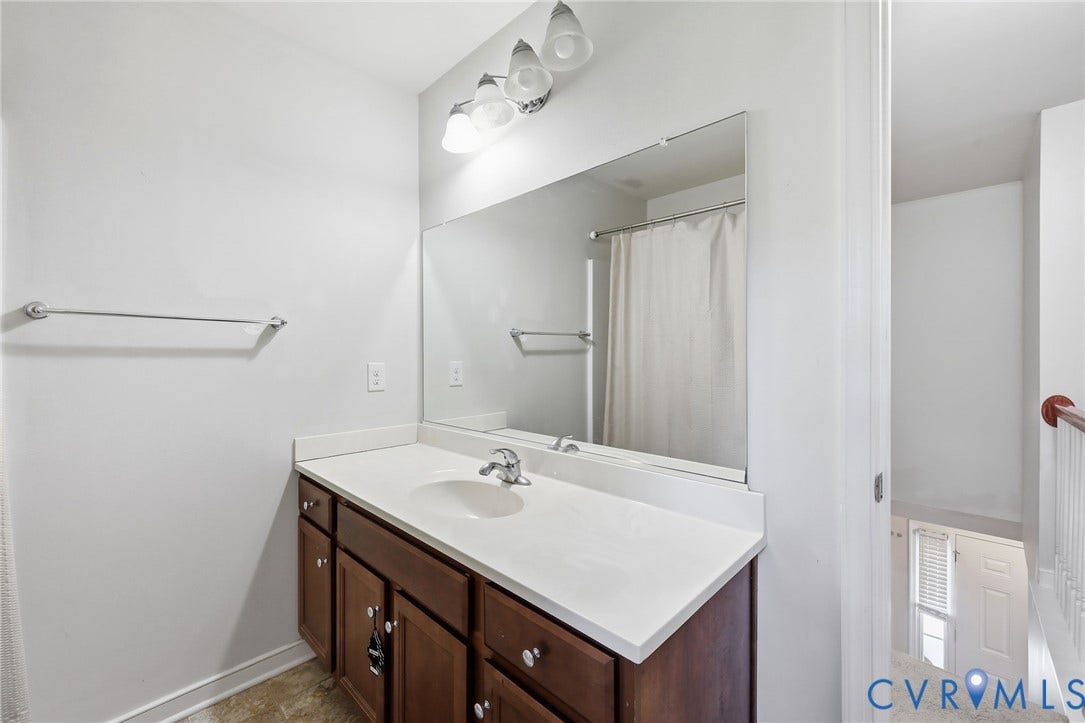 10155 Virginia Road, Glen Allen, VA 23060 Bathroom vanity featuring a single basin, laminate countertop, and wood-finish cabinetry