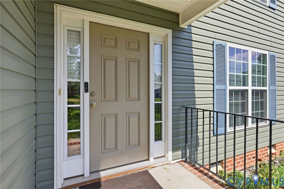 10155 Virginia Road, Glen Allen, VA 23060 Entryway featuring a panel door with side lites, green siding, and a window with blue louvered shutters