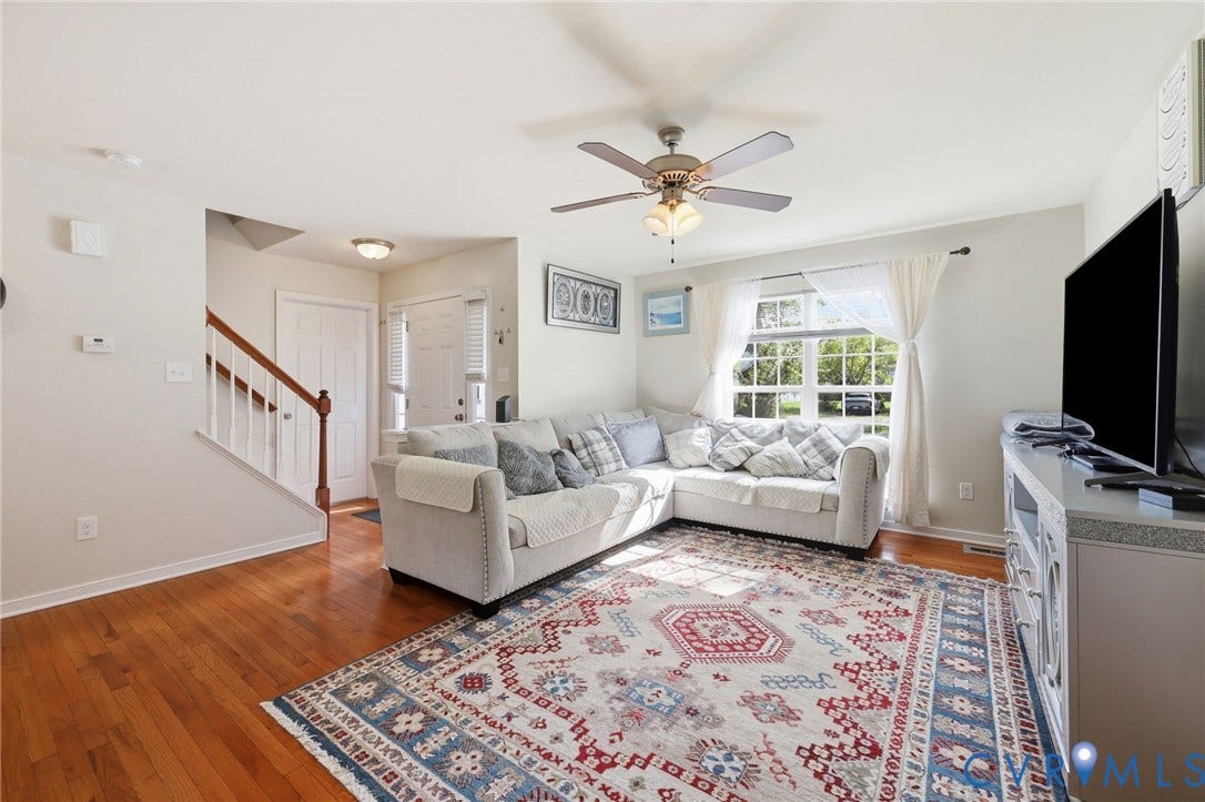 10155 Virginia Road, Glen Allen, VA 23060 Bright living area featuring wood-finish flooring, a ceiling fan with integrated lighting, and a large window