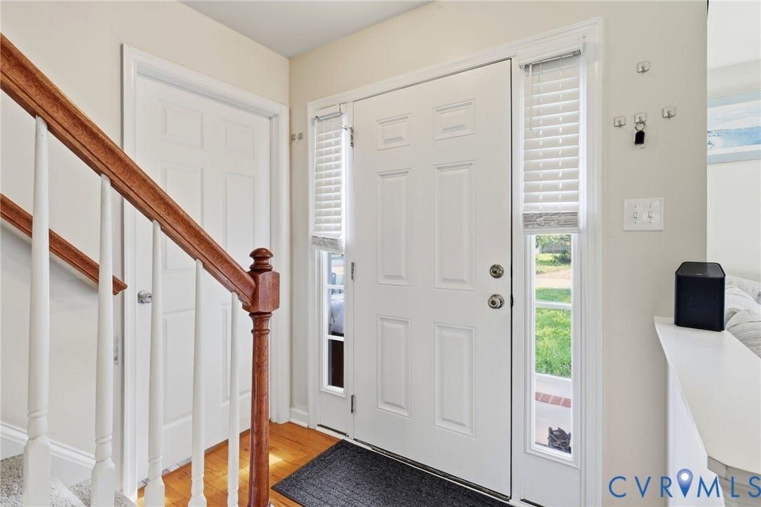 10155 Virginia Road, Glen Allen, VA 23060 Entryway featuring a paneled door with sidelight, wood-finish flooring, and a staircase with wood newel post and handrail