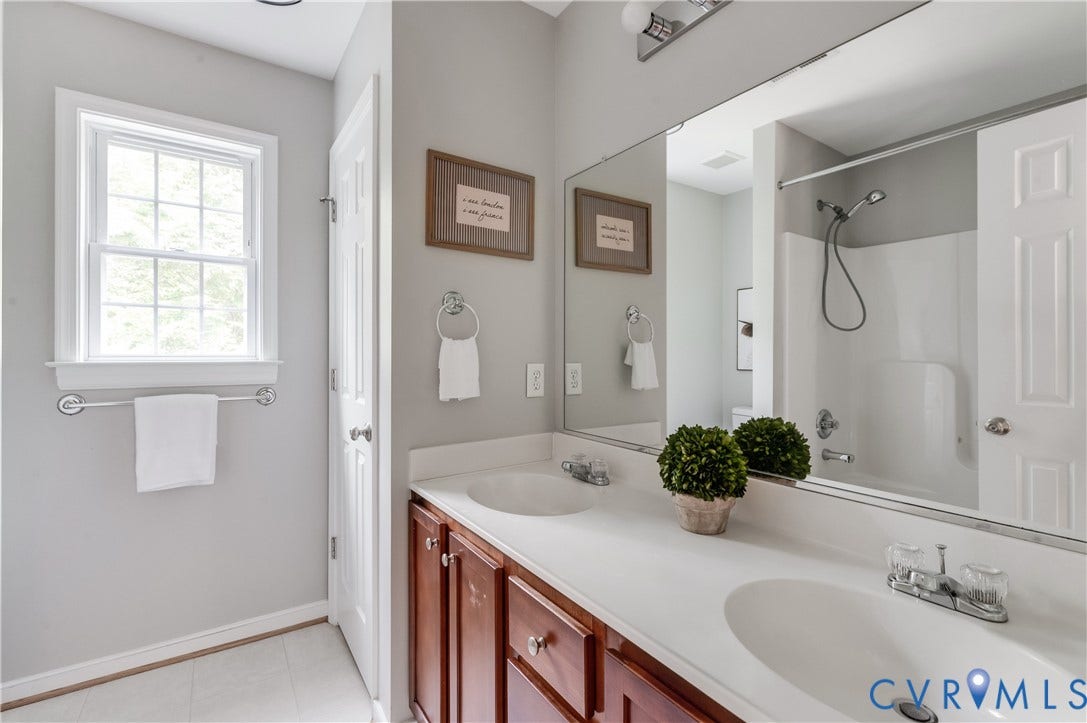 384 Tillar Lane, Mineral, VA 23117 Bathroom featuring a double vanity with white countertops, integrated sinks, and wood-finish cabinetry