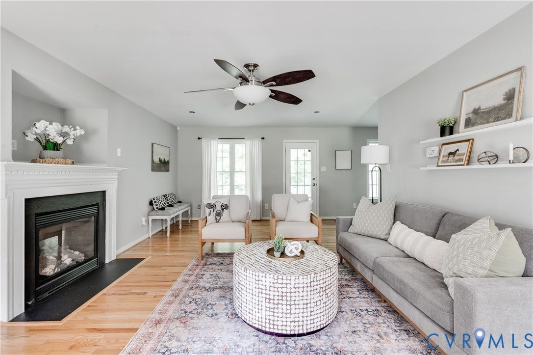384 Tillar Lane, Mineral, VA 23117 Living area featuring light wood-finish flooring, a white mantel fireplace with a black hearth, and a ceiling fan with integrated lighting