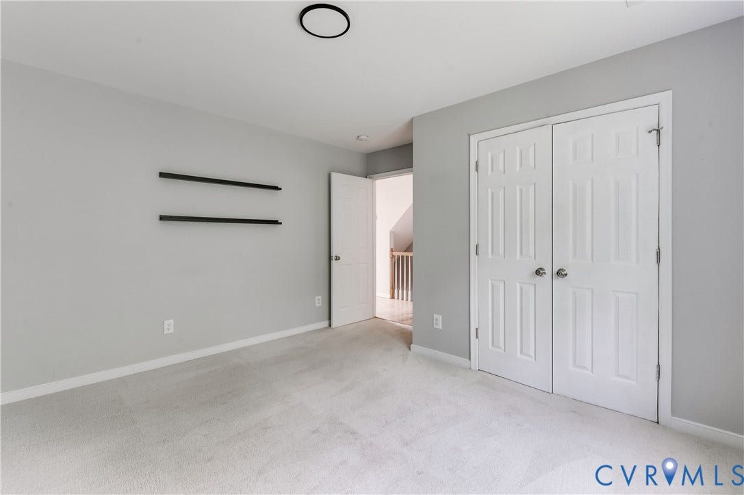 384 Tillar Lane, Mineral, VA 23117 Carpeted room with light gray walls, featuring a white bi-fold closet door, a white six-panel door, and a flush-mount ceiling light fixture