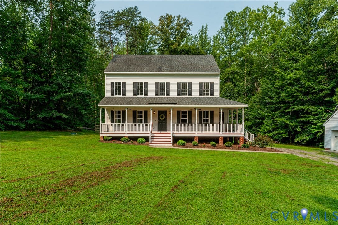 384 Tillar Lane, Mineral, VA 23117 Two-story Colonial-style residence featuring white siding, a dark shingle roof, black shutters, and a full-width front porch