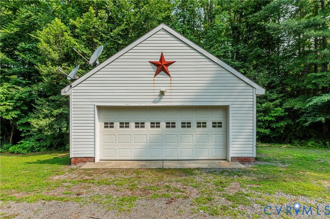 384 Tillar Lane, Mineral, VA 23117 White vinyl-sided garage featuring a gable roof and a two-car garage door with window inserts