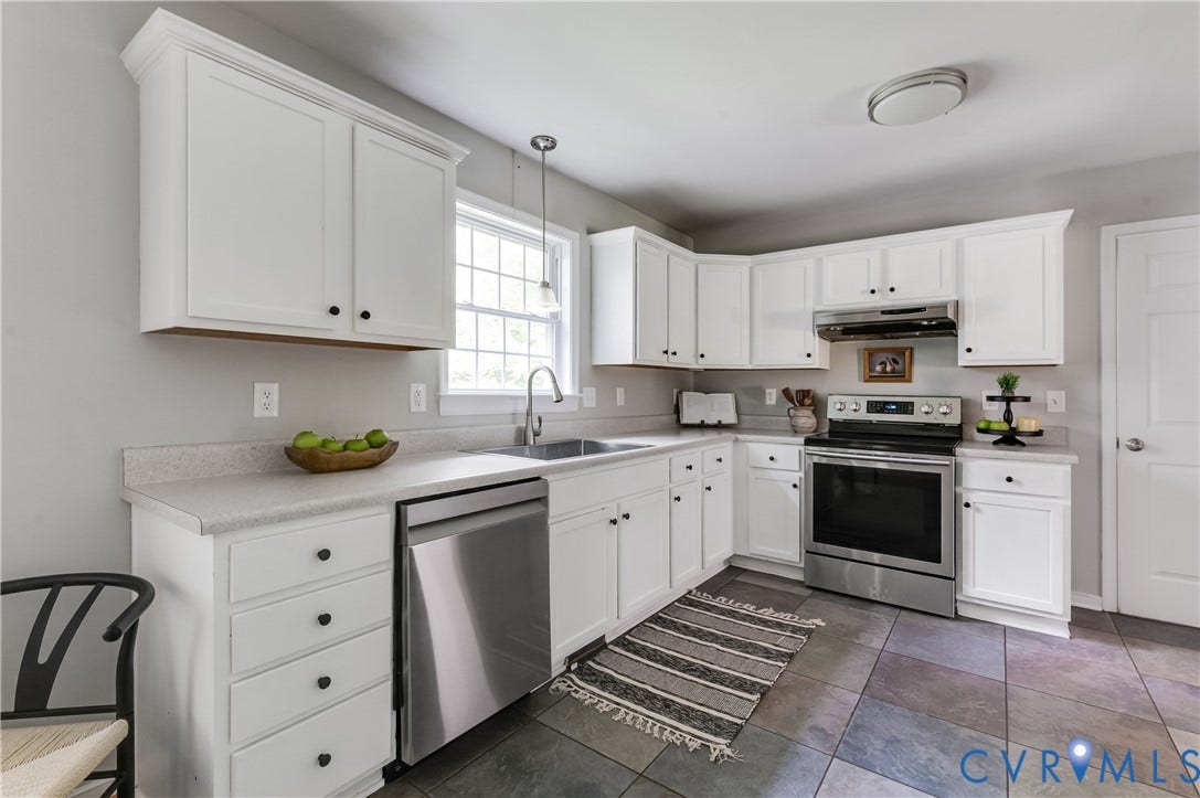 384 Tillar Lane, Mineral, VA 23117 L-shaped kitchen featuring white cabinetry, light countertops, stainless steel appliances, and slate-style floor tiling