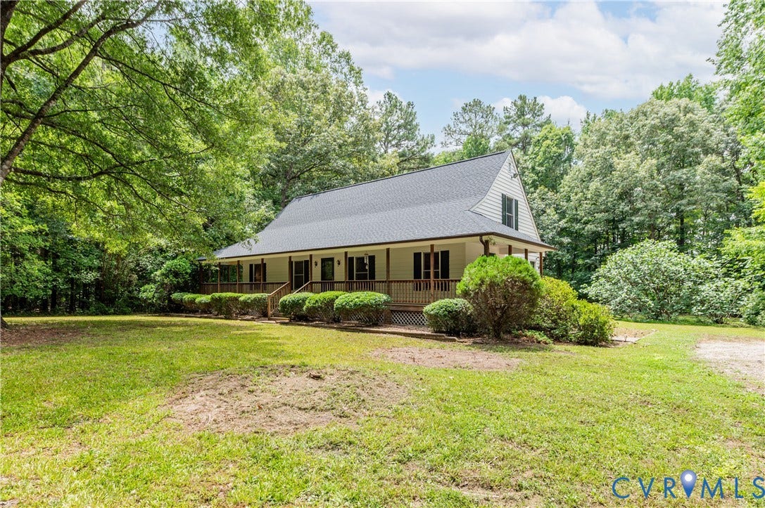 4415 Spoonbill Drive, Powhatan, VA 23139 Expansive grassy yard surrounding a home with a covered front porch, dark-paned windows, and a black shingle roof