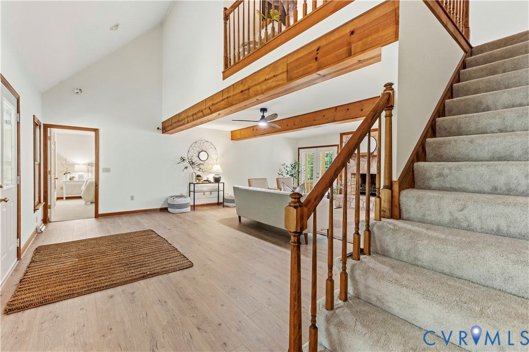4415 Spoonbill Drive, Powhatan, VA 23139 Two-story foyer featuring vaulted ceilings, wood-finish flooring, exposed wood beams, and a carpeted staircase with a wood railing