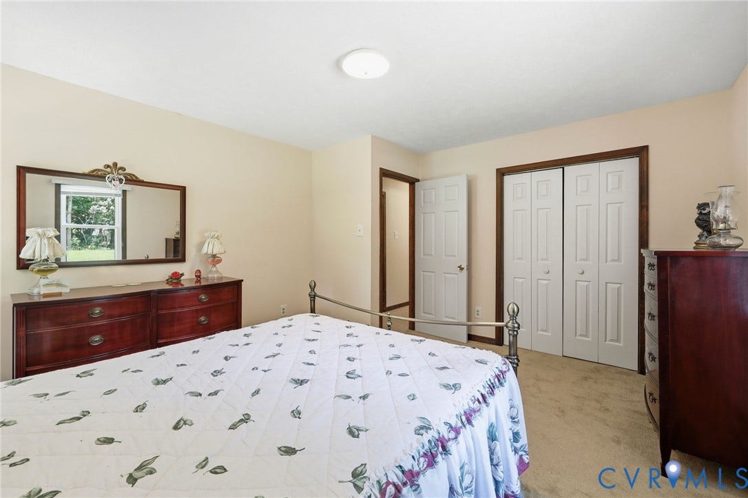 10111 Tunstall Road, New Kent, VA 23124 Bedroom featuring neutral wall paint, carpet flooring, a window offering exterior views, and a closet with bifold doors