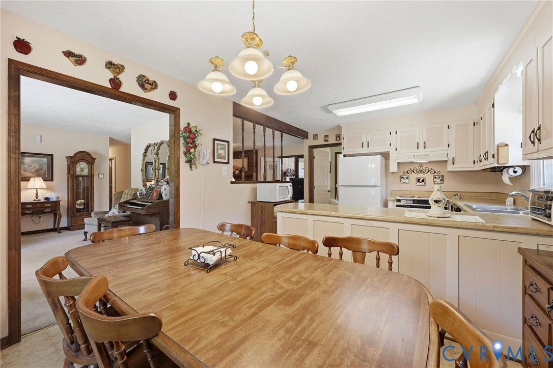 10111 Tunstall Road, New Kent, VA 23124 Kitchen and dining area featuring light-toned cabinetry, a counter-height breakfast bar, and a recessed ceiling light