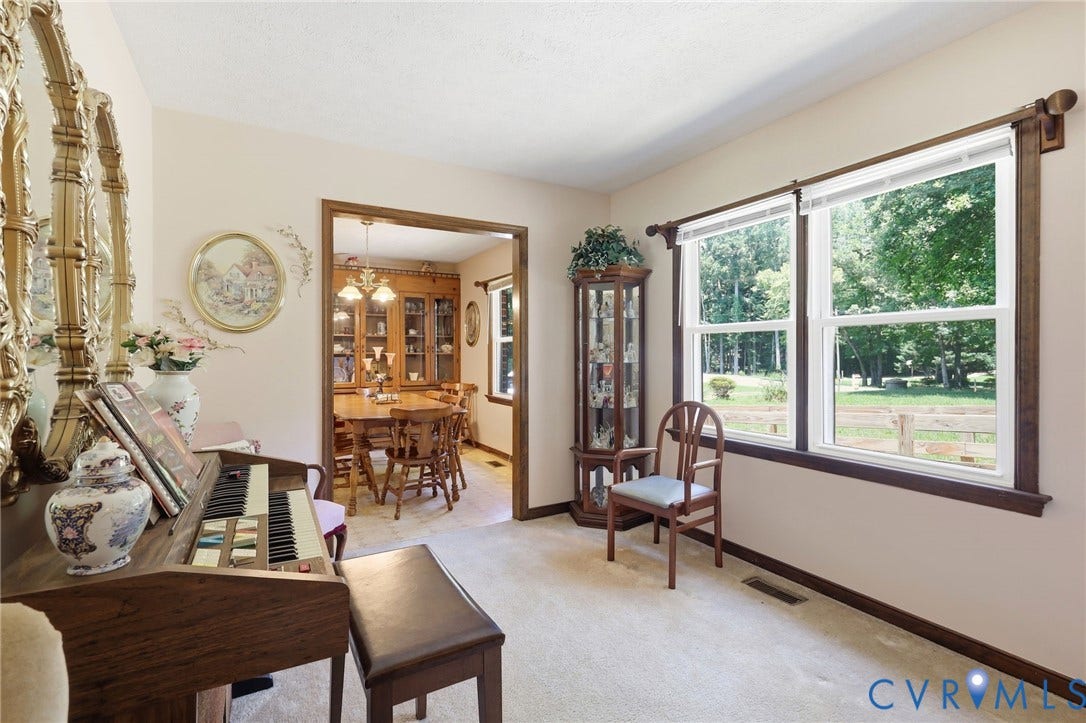 10111 Tunstall Road, New Kent, VA 23124 Carpeted room with double-hung windows featuring wood trim, offering expansive outdoor scenery