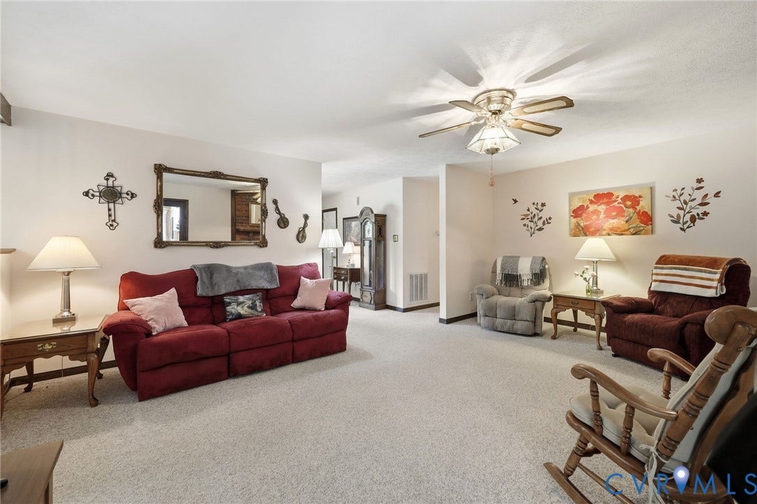 10111 Tunstall Road, New Kent, VA 23124 Spacious living area featuring light-toned carpeting, a ceiling fan with integrated lighting, and neutral wall tones