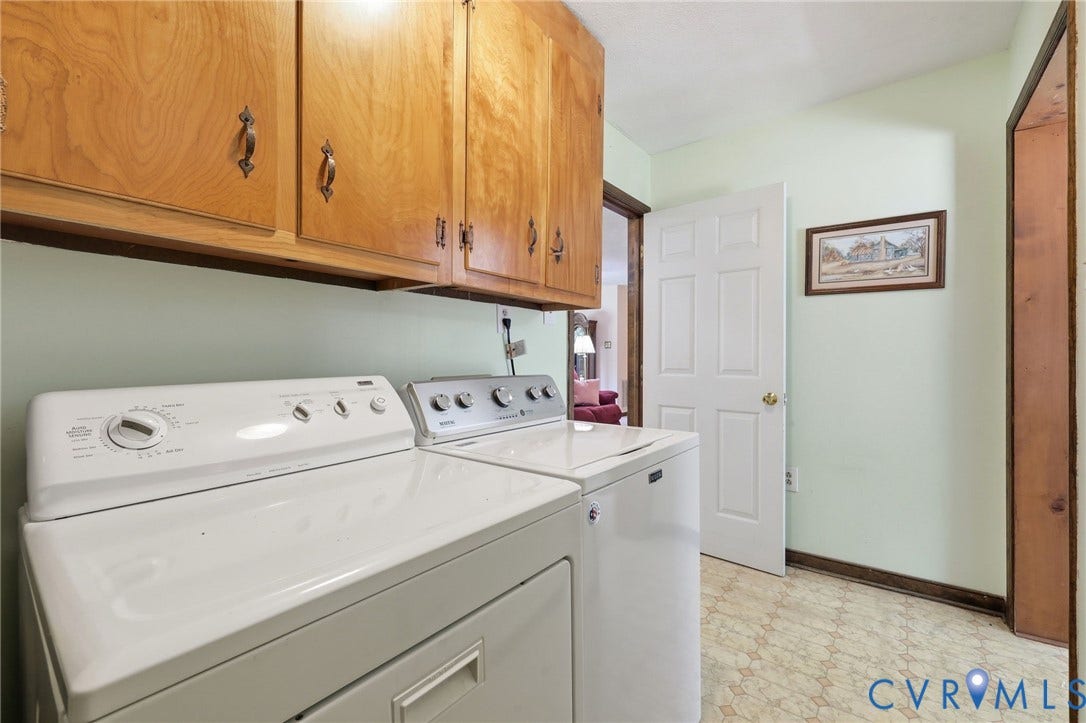 10111 Tunstall Road, New Kent, VA 23124 Functional utility space featuring wood cabinetry, light green wall paint, and patterned vinyl flooring