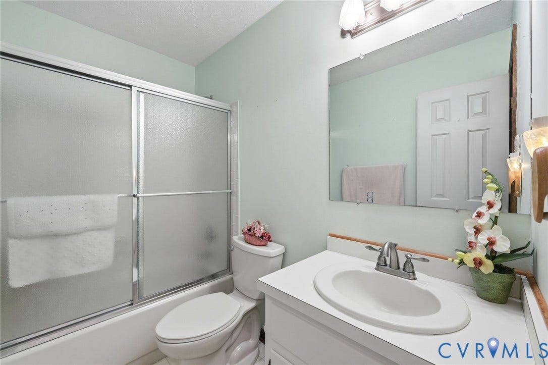 10111 Tunstall Road, New Kent, VA 23124 Bathroom featuring a white vanity with an integrated sink, brushed nickel faucet, and a large wall-mounted mirror