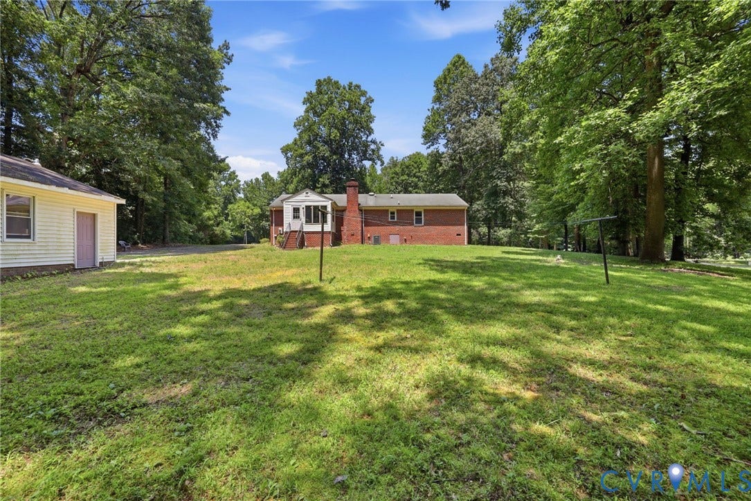 10111 Tunstall Road, New Kent, VA 23124 Expansive grassy yard area with mature trees and a detached yellow siding outbuilding